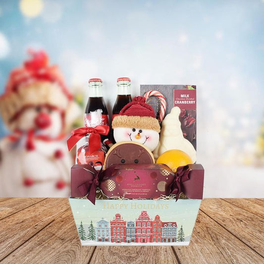 The Sweetest Season Christmas Gift Basket - Featured in this gift set two glass bottles of Coca-Cola, a Hollyberry cracker box of truffles, a white chocolate Santa, milk chocolate cranberries, mini sour cherry bombs from Monarch, a classic candy cane, a handmade round reindeer cookie, an orange, a cute plush snowman ornament, and a gift tray that says “Happy Holidays”